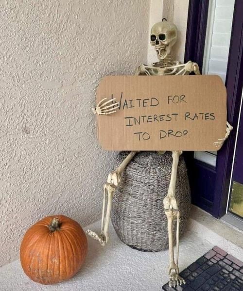 a skeleton sitting on top of a pot with a sign that says, i ate for interest rate to drop