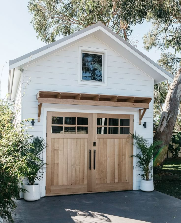 a white house with two wooden garage doors