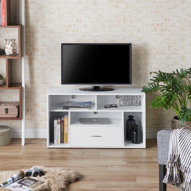 a flat screen tv sitting on top of a white entertainment center in a living room