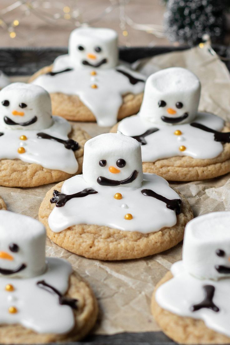 cookies decorated with marshmallows and frosting are arranged in the shape of snowmen