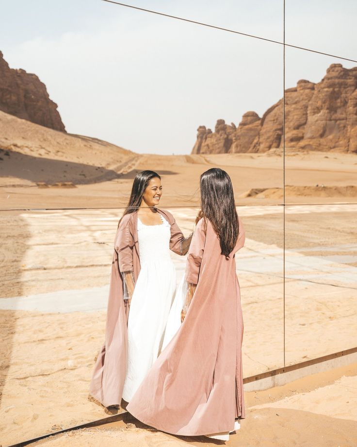 two women walking in the desert holding hands