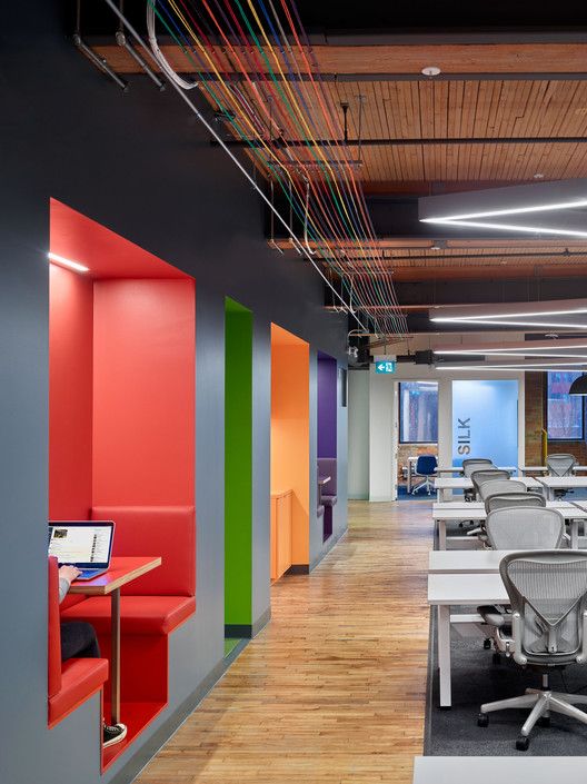 an empty office with colorful walls and desks