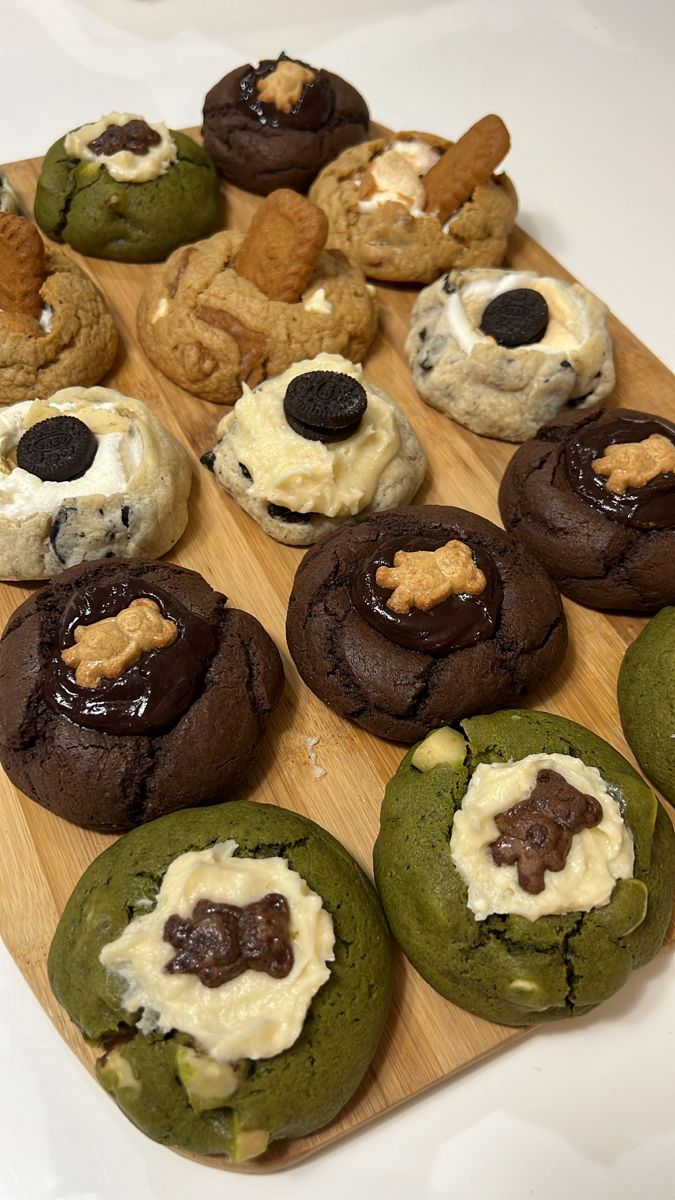 a wooden board topped with cookies covered in frosting