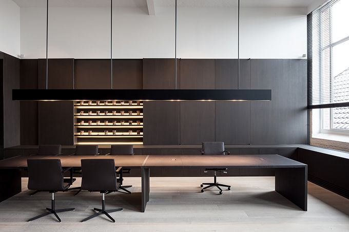 an empty conference room with several chairs and a table in front of a wine rack