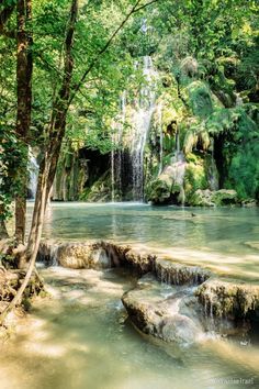 a small waterfall in the middle of a forest