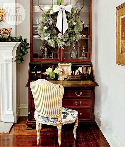 a chair sitting in front of a desk with a wreath on it