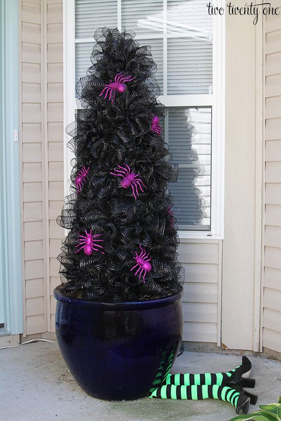 a black and purple tree with pink spider decorations