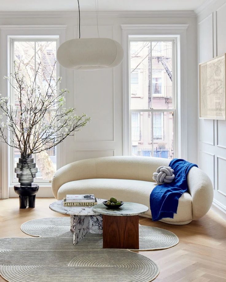 a living room filled with furniture and lots of window sill space in front of two large windows