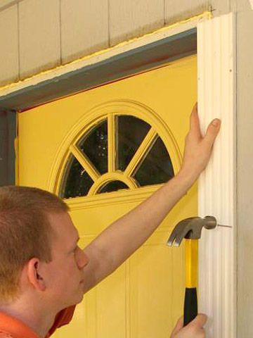 a man is opening the front door with a hammer