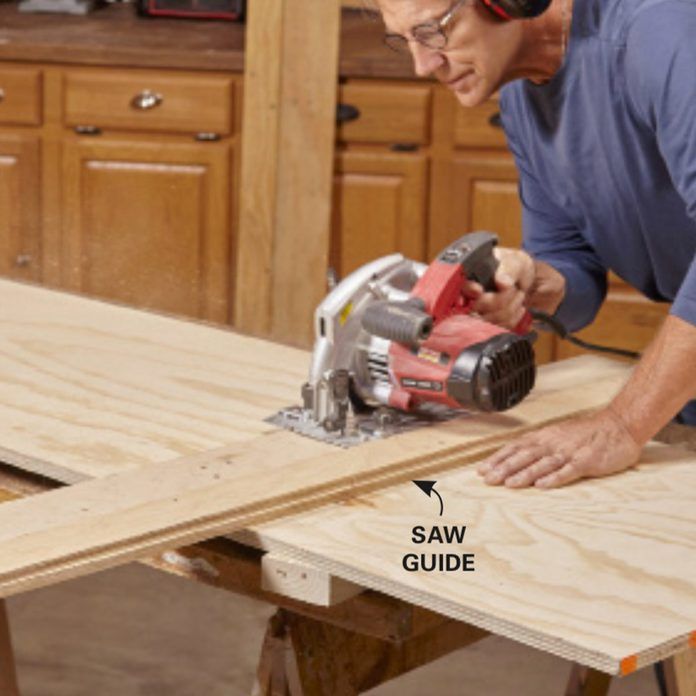 a man using a circular saw to cut plywood planks with a jig