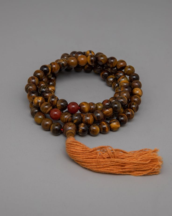 AAA Grade Tiger Eye Japa Mala About our Mala beads Our AAA Grade Brown Tiger Eye Japa Mala handcrafted with 8mm beads, represents spiritual strength and grounding. Each bead, infused with the captivating colors of brown Tiger Eye, exudes protection and vitality, guiding you on a journey of inner transformation and empowerment. Carnelian dividers are delicately incorporated into this mala, adding to its beauty and functionality by providing a seamless transition between beads and infusing your me Hand-strung Spiritual Beads For Blessing, Artisan Wooden Beads Bracelet For Meditation, Artisan Beaded Mala For Meditation, Artisan Wooden Beads For Meditation, Artisan Wooden Meditation Beads, Spiritual Brown Mala With Polished Beads, Brown Mala With 8mm Beads For Rituals, Brown Spiritual Mala With Polished Beads, Brown 8mm Beads Mala For Rituals