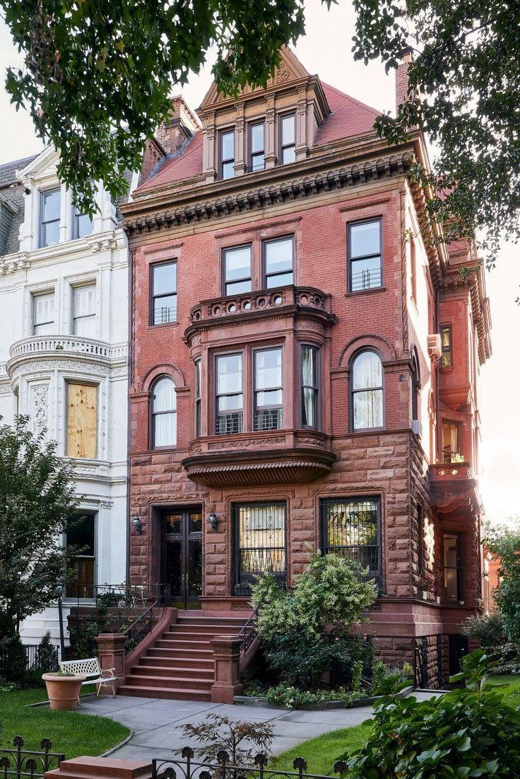 an old brick house with many windows and stairs