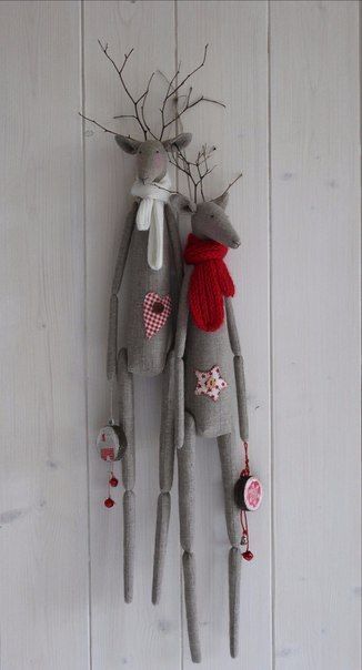 two stuffed animals hanging from the side of a white wall with red and pink decorations