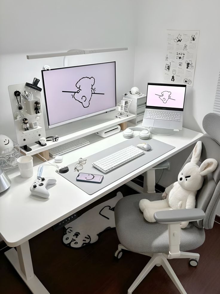 a white desk with two computer monitors and a stuffed bunny sitting on the chair in front of it