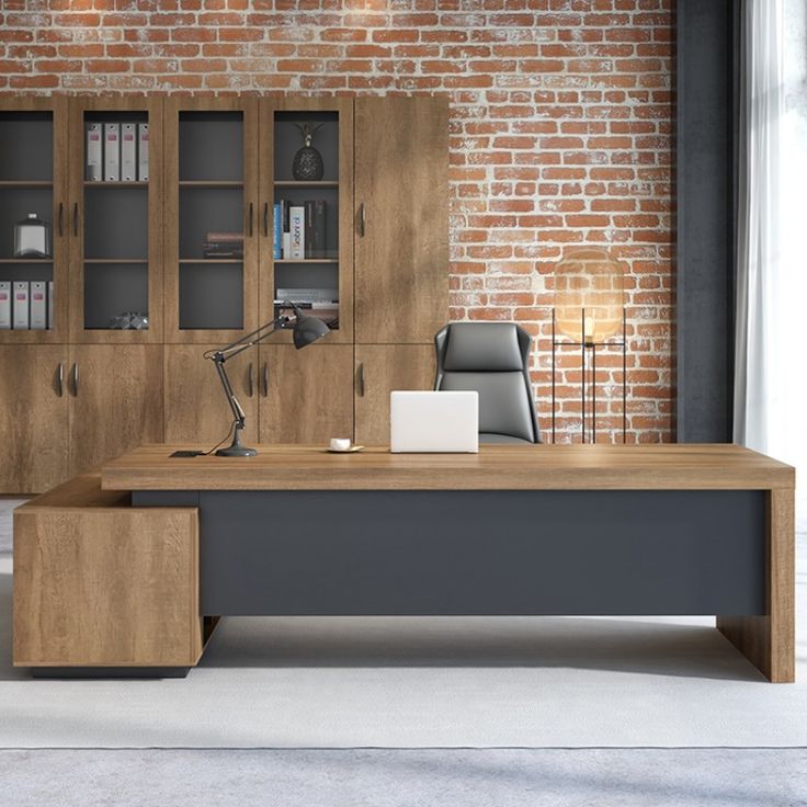 an office desk in front of a brick wall