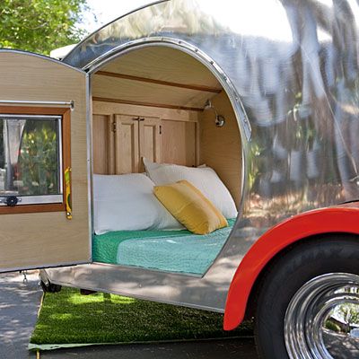 an old camper trailer converted into a mobile home with a bed in the back