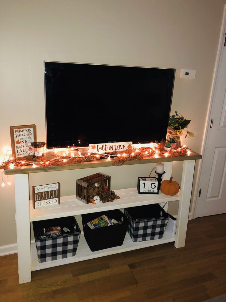 an entertainment center with lights and decorations on the top, along with two bins