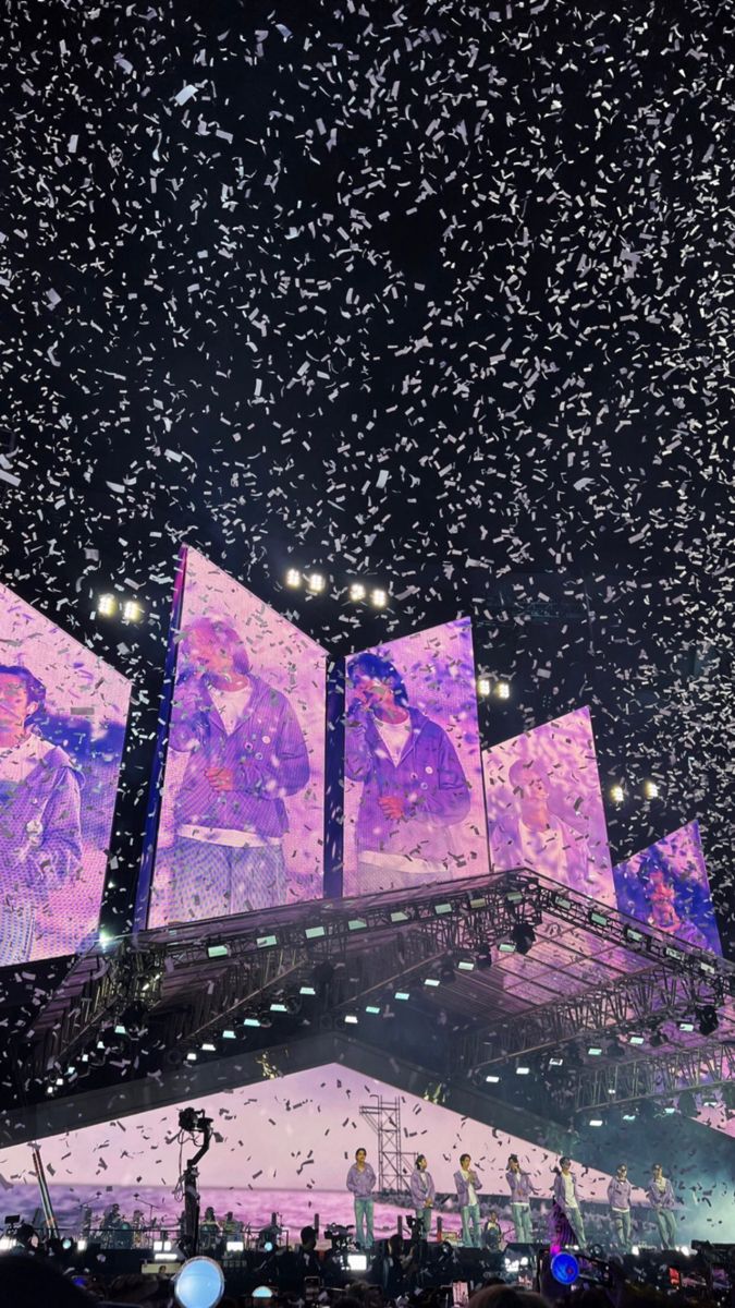 the stage is lit up with purple lights and confetti