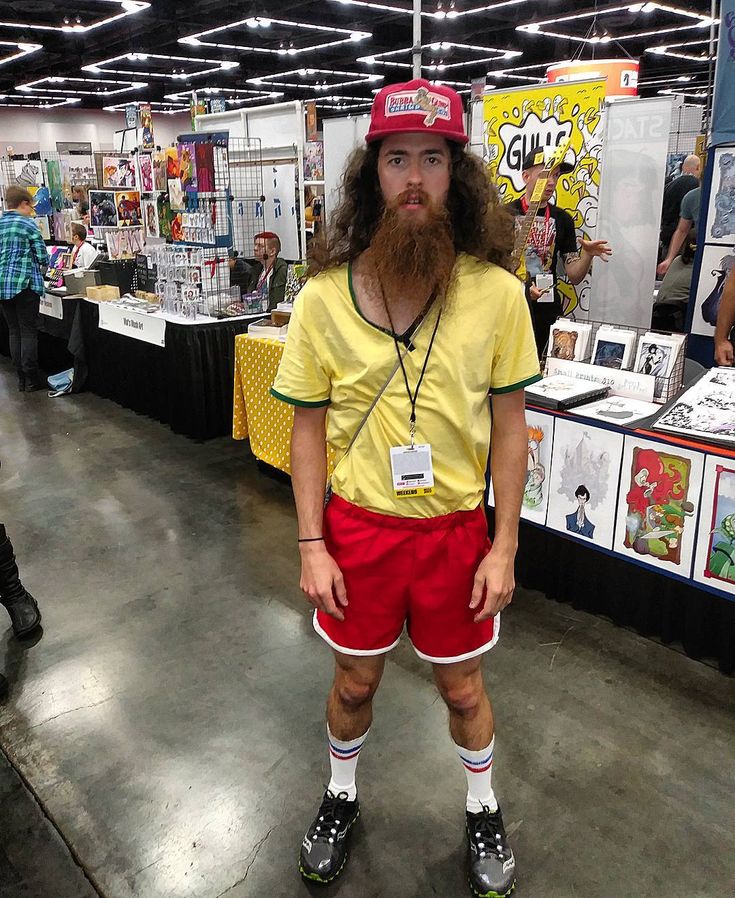 a man with a long beard wearing red shorts and a yellow shirt