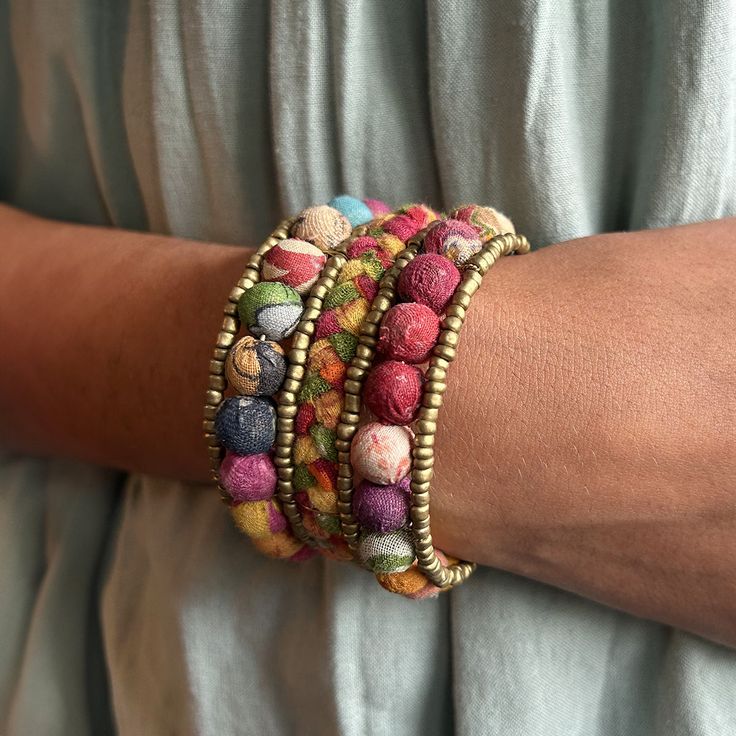 Two rows of colorful Kantha beads bookend a row of braided Sari textiles. Each is accented with matte gold seed beads for a subtle pop of shimmer. Made from repurposed Kantha textiles so the colors and patterns will vary slightly. Sustainably handmade by women artisans in India. Artisan Multicolor Beaded Bracelets For Festivals, Multicolor Bohemian Beaded Bracelet For Festive Occasions, Multicolor Bohemian Beaded Bracelets For Festive Occasions, Traditional Multicolor Beaded Bracelets For Festive Occasions, Festive Bohemian Beaded Bracelets With Colorful Beads, Spiritual Multicolor Beaded Bracelets With Gold Beads, Bohemian Beaded Bracelets With Round Beads For Festive Occasion, Festive Multicolor Traditional Beaded Bracelets, Bohemian Multicolor Beaded Bracelets For Festivals