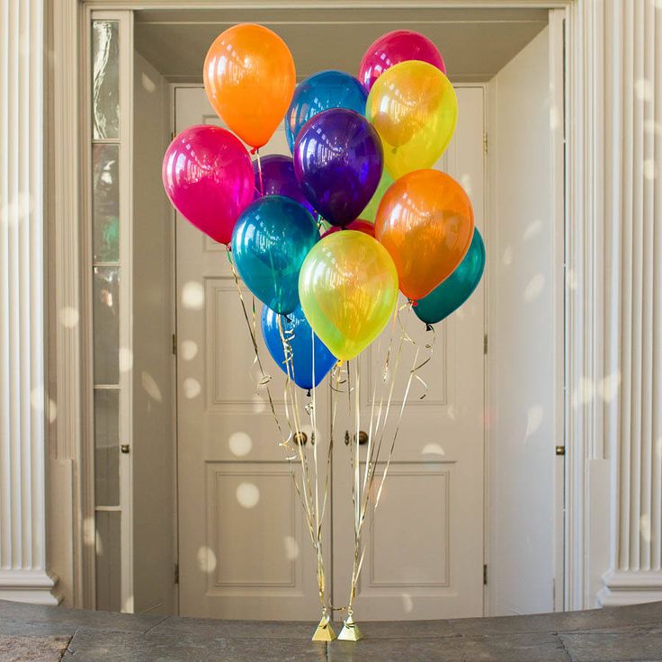 a bunch of balloons that are sitting in the middle of a room with white columns