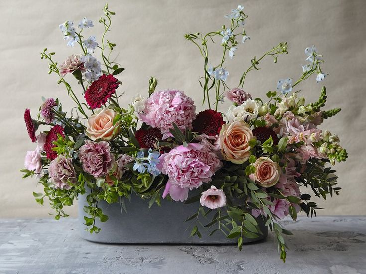 a vase filled with lots of flowers on top of a table