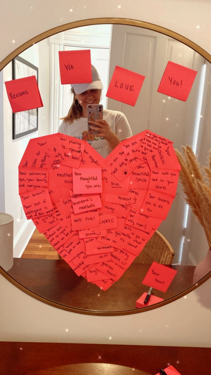 a woman taking a selfie in front of a mirror with sticky notes on it