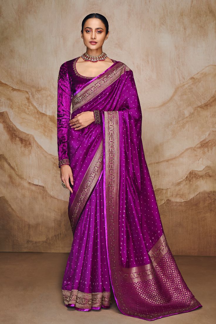 Purple saree with bandhani, floral woven motifs and contrast gold border. Paired with full sleeve velvet blouse. Components: 2 Pattern: Woven Type Of Work: Floral, bandhani Neckline: Scoop neck Sleeve Type: Full sleeves Fabric: Saree: Viscose, Blouse: Velvet Color: Purple Other Details:  Contrast gold border Embroidered neckline Attached lining Occasion: Wedding - Aza Fashions Full Sleeves Blouse Designs, Velvet Blouse Design, Velvet Saree, Full Sleeve Blouse, Floral Saree, Purple Saree, Velvet Blouse, Yellow Saree, Saree Blouse Designs Latest