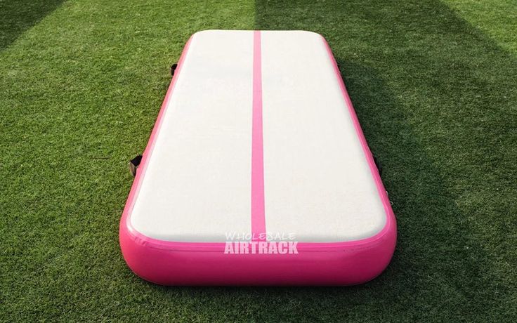 a pink and white inflatable mattress laying on the grass