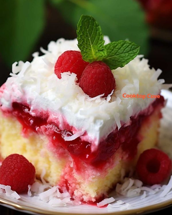 a piece of cake on a plate with raspberries and coconut