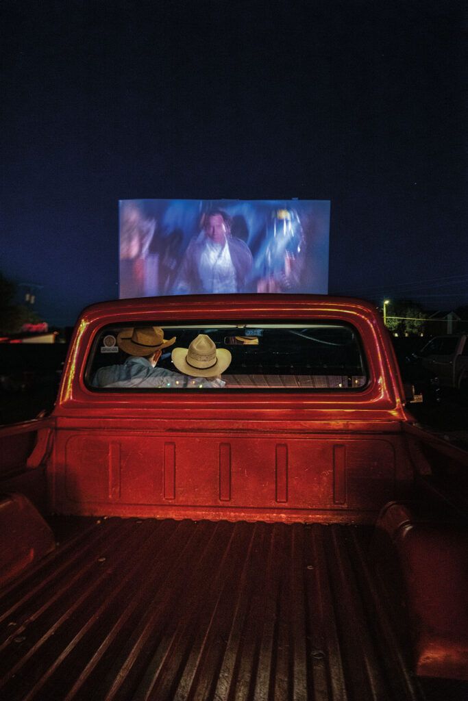 the back end of a red pickup truck with a screen on it