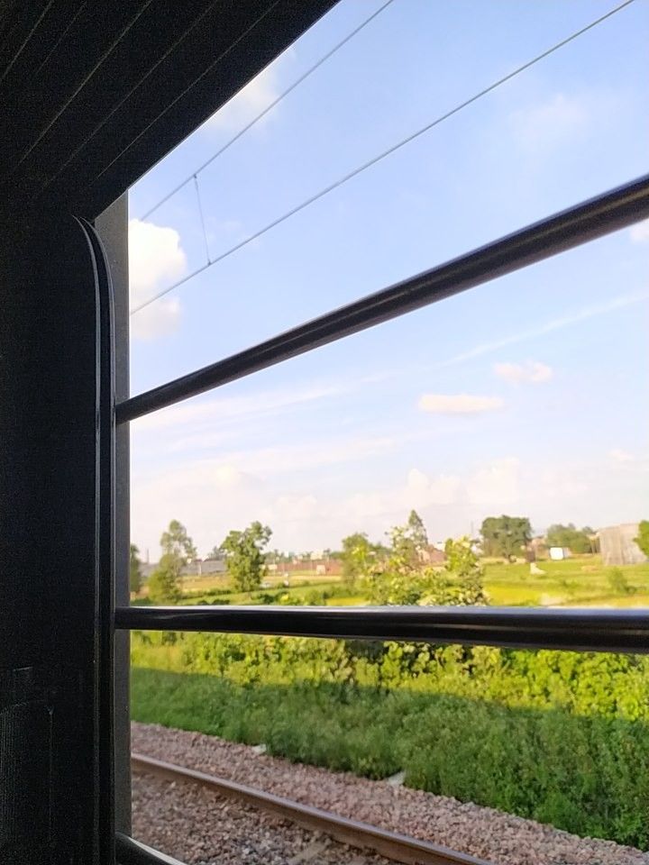 a view out the window of a train traveling through rural countryside