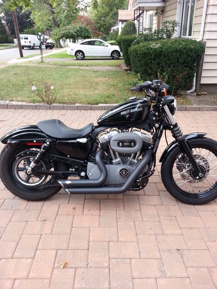 a black motorcycle parked in front of a house