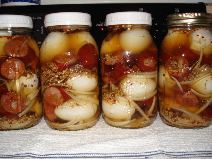 four jars filled with food sitting on top of a counter