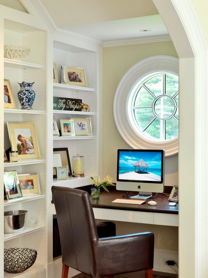 a computer on a desk in front of a window