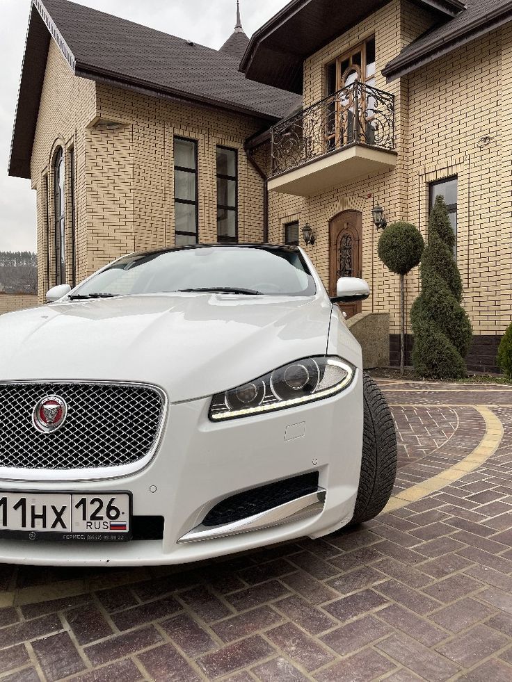 a white car parked in front of a house