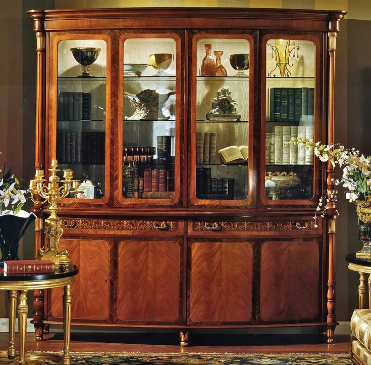 a wooden china cabinet with glass doors and shelves