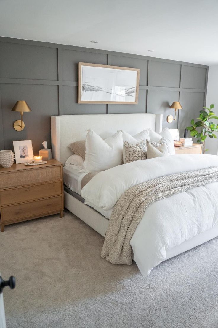 a bedroom with gray walls, white bedding and beige accents is pictured in this image