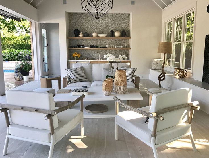 a living room filled with white furniture and lots of windows