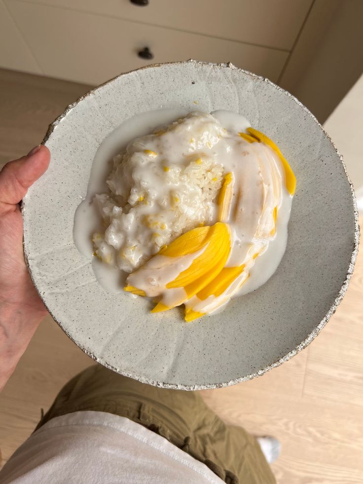 a person holding a white plate with food on it