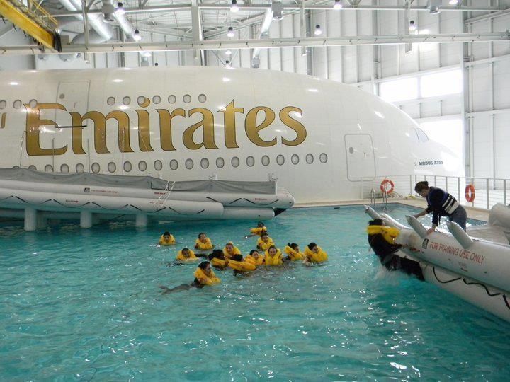 people are in the water with rafts near an airplane that is painted white and gold