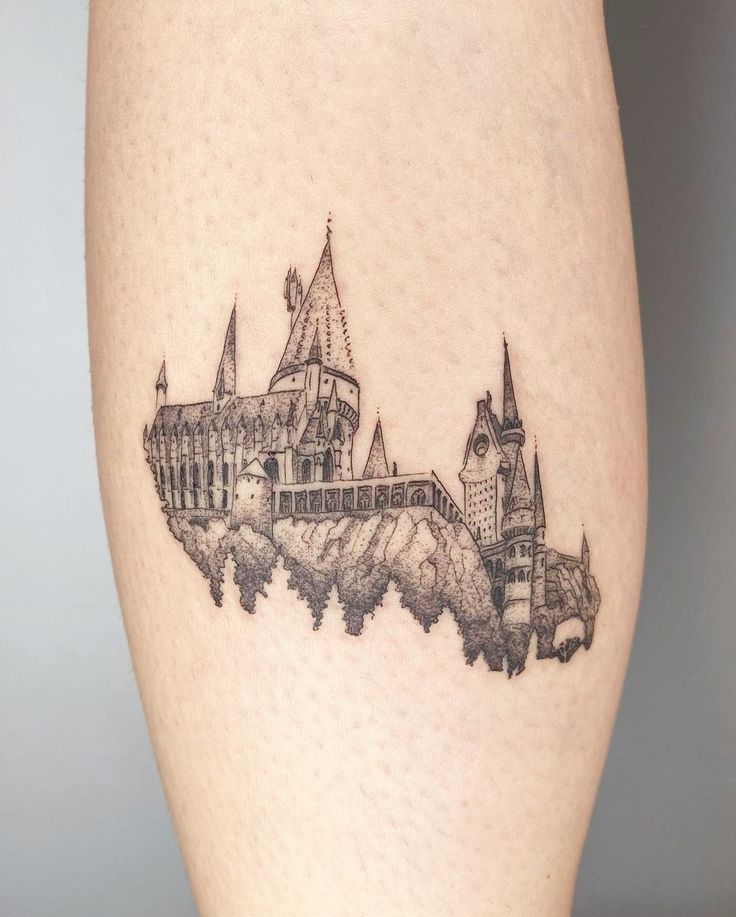 a hogwarts castle tattoo on the right thigh is shown in black and white