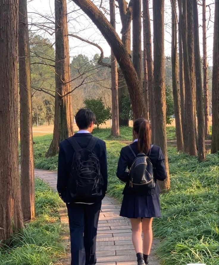 two people walking down a path in the woods