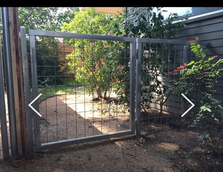 a gate that has been installed to the side of a house with an arrow pointing towards it