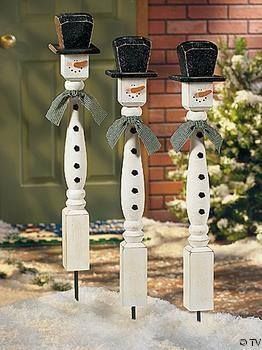 two white candlesticks with black top hats and bow ties are standing in the snow