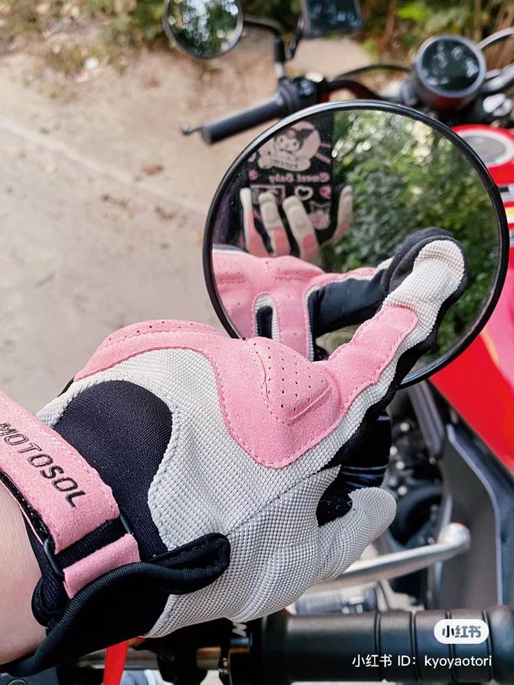 a close up of a person's hand on a motorcycle mirror