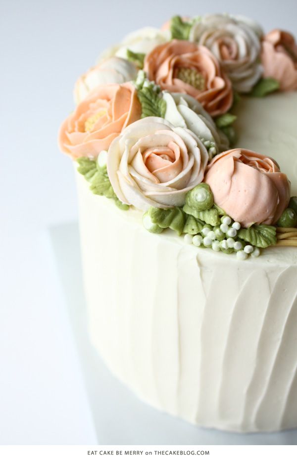 a close up of a cake with frosting flowers on the top and bottom layer