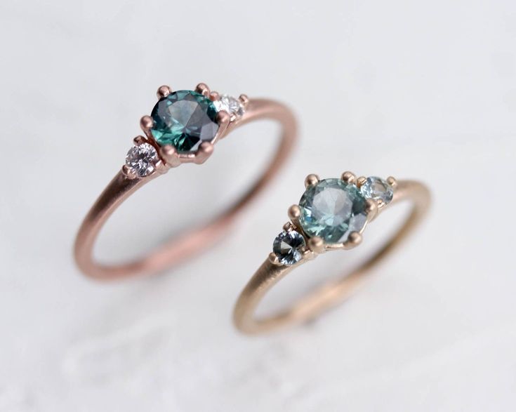 two rings with blue and white diamonds on them, one is in the shape of an oval