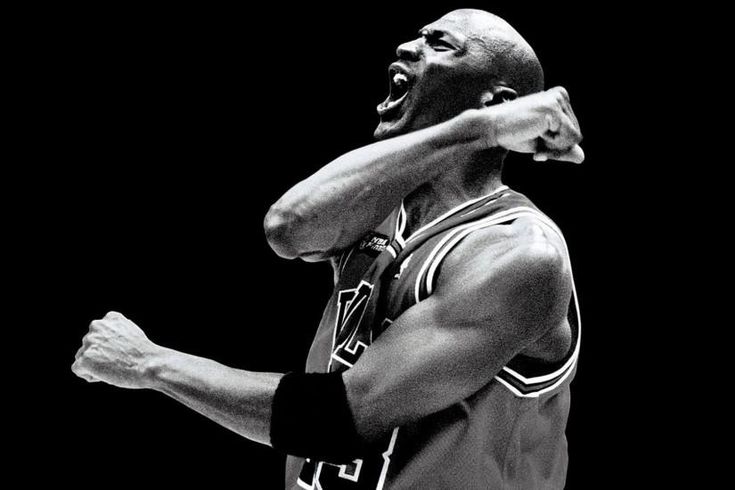 a black and white photo of a basketball player with his hands on his chest, shouting