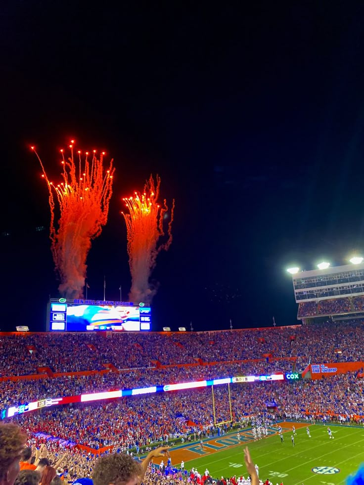 fireworks light up the night sky at a football game